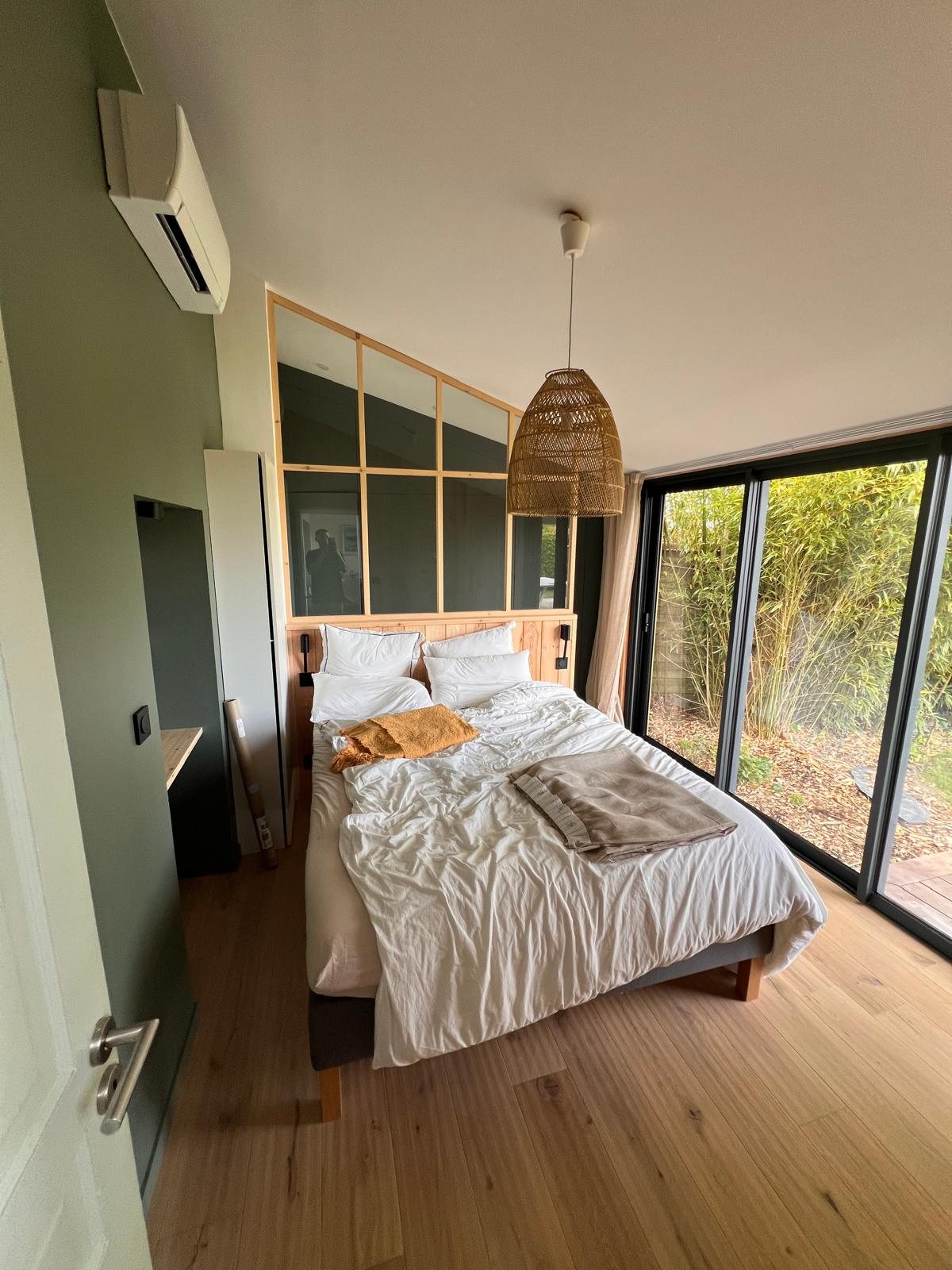Chambre avec mur vert et verrière