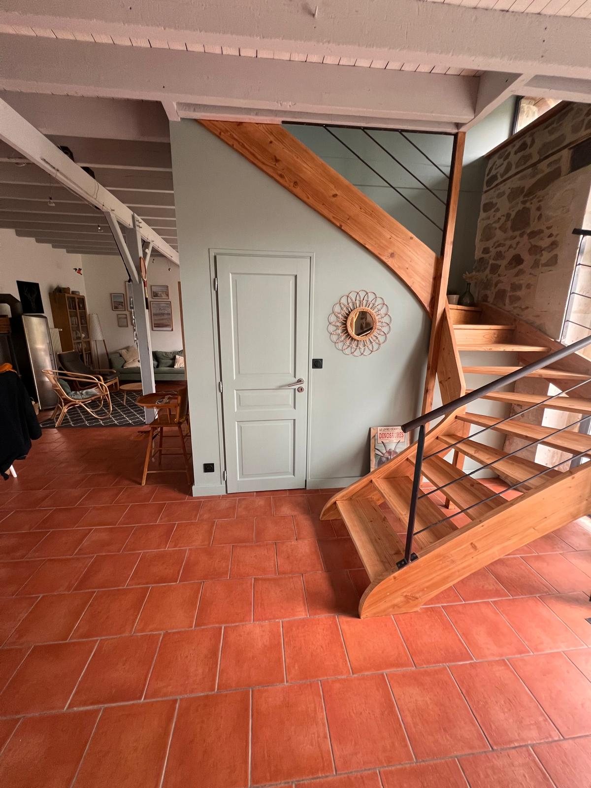 Entrée avec escalier bois et murs sauge