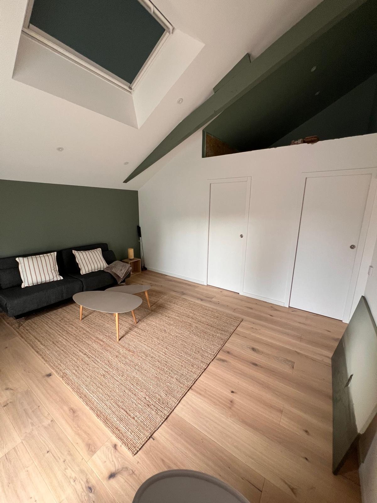 Pièce sous combles avec mur vert et placards blancs